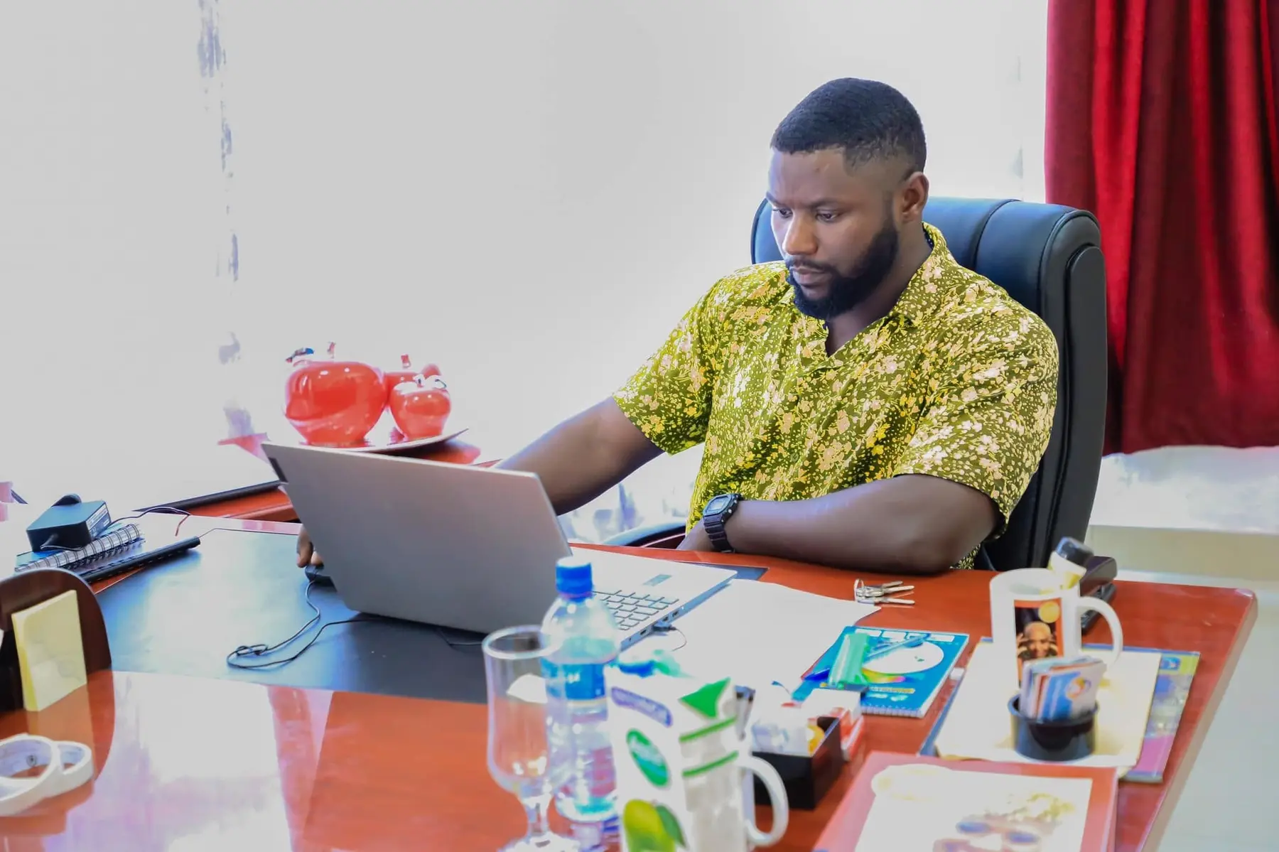 Kubwimana Martin working at his desk in Bujumbura